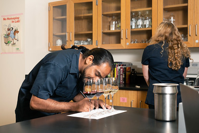 student writing notes on a wine sample