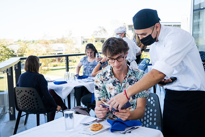 student giving info on food order at student run restaurant