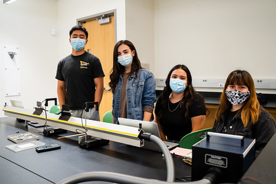 four physics students in a classroom